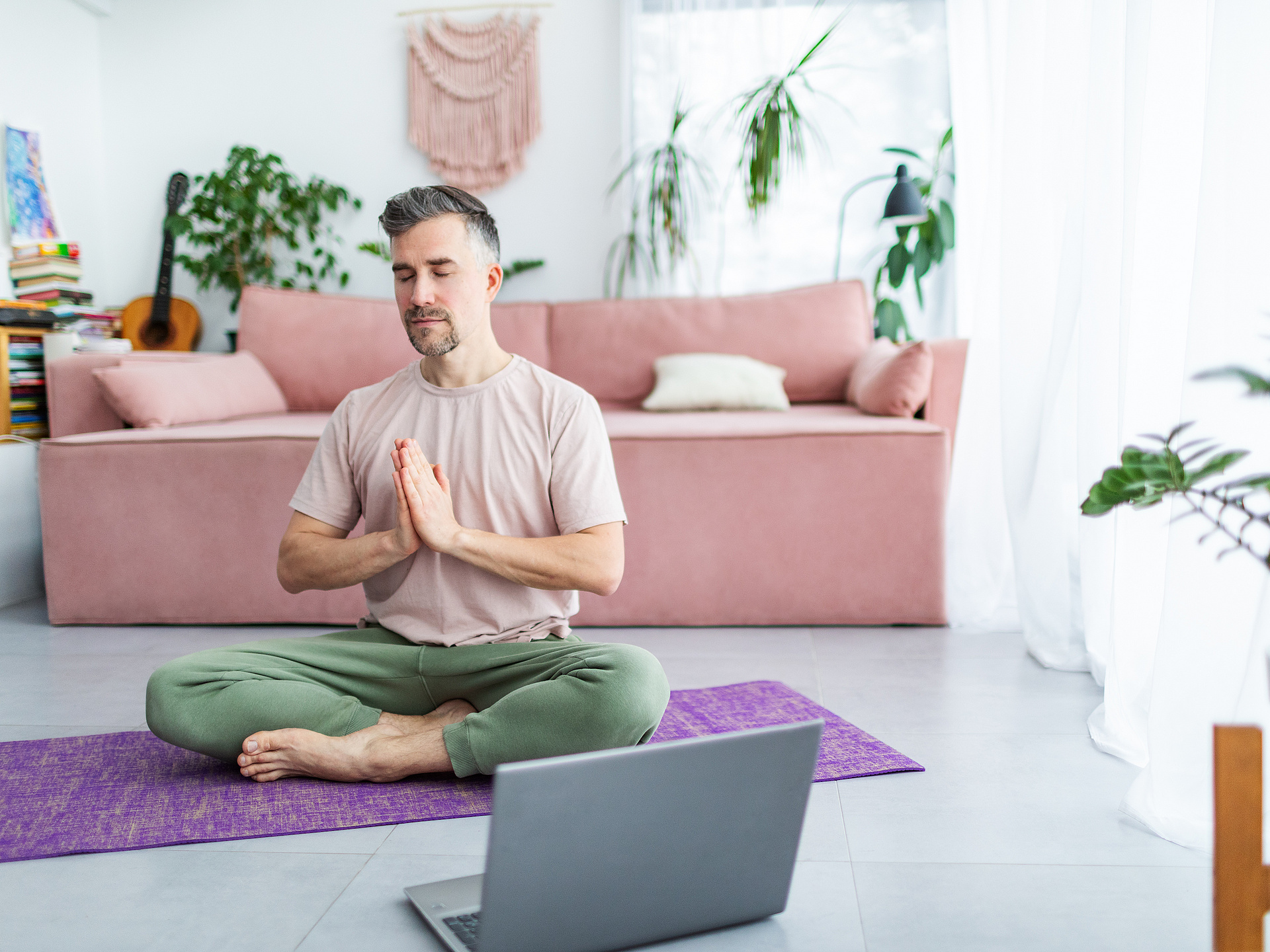 Mann beim Yoga mit Laptop